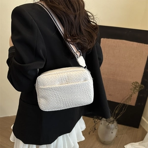 Chic white woven pattern crossbody bag with striped wide shoulder strap and metal hardware