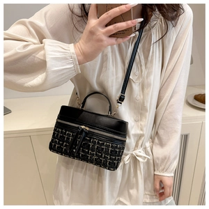 Mirror selfie showing the black box bag with tweed panels and adjustable strap