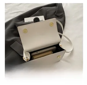 Internal capacity of the white leather crossbody bag showing phone and wallet storage