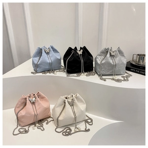 Detailed view of bucket bags in five colors with metal butterfly and pearl chain