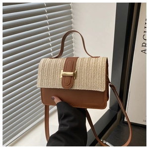 Detail of woven straw and brown leather contrast on crossbody bag with gold H buckle