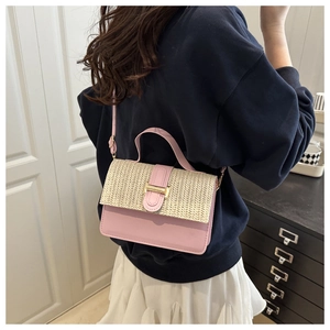 Detail of pink leather and beige woven straw crossbody bag with gold metallic buckle
