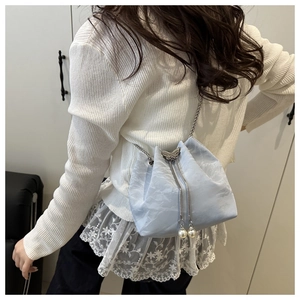 Light blue bucket bag with silver butterfly charm and pearl drawstring details