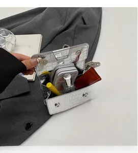 Interior view of silver crocodile pattern crossbody bag showing space for cosmetics
