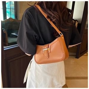Vista posteriore di una modella con borsa a tracolla in pelle marrone e fibbia oro