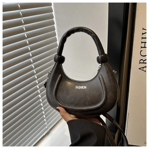 Detail of black half-moon handbag with fashion lettering and matte synthetic leather