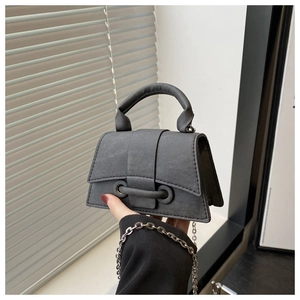 Detail of dark grey micro square bag with textured leather and silver chain strap
