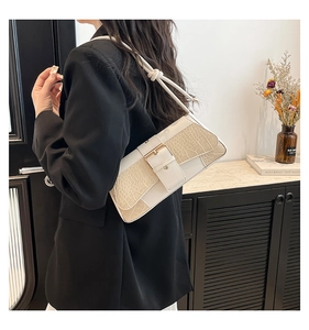 Detail of white crocodile pattern shoulder bag with golden buckle on female model