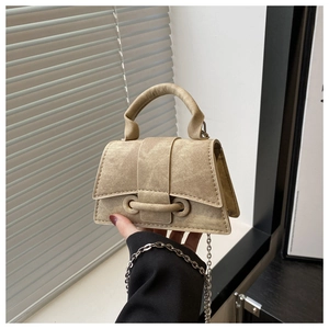 Detail of vintage khaki mini crossbody bag with textured denim fabric and silver chain strap