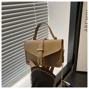 Close-up of khaki PU leather mini handbag with gold hardware and chain strap details