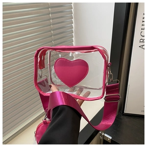 Dettaglio borsa a tracolla in PVC trasparente rosa con patch a cuore e mini borsellino
