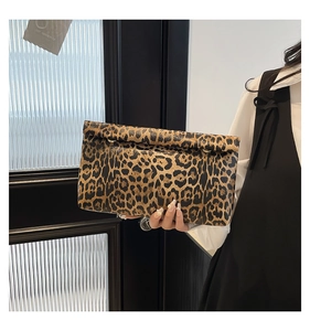Detail of leopard print folding clutch bag featuring metallic hardware and texture