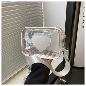 Dettaglio della borsa a tracolla in PVC trasparente con patch a cuore bianco e tracolla