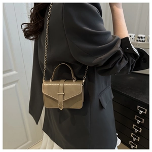 Detail of khaki crossbody square bag with gold chain strap and metal triangle buckle