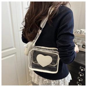 Dettaglio borsa a tracolla in PVC trasparente con toppa a cuore bianca e mini borsellino