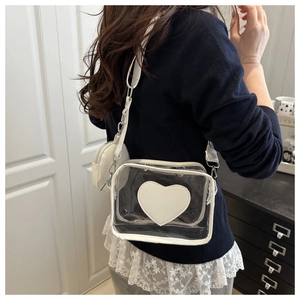 Dettaglio borsa a tracolla in PVC trasparente con patch cuore bianco e portamonete