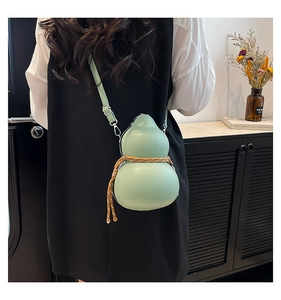Gros plan sur le sac bandoulière vert clair en forme de gourde avec cordon décoratif