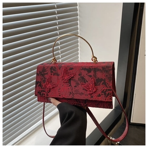 Close-up of red floral crossbody bag with 3D butterfly embroidery and gold handle