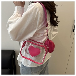 Dettaglio della borsa a tracolla in PVC trasparente con toppa a cuore magenta e borsellino