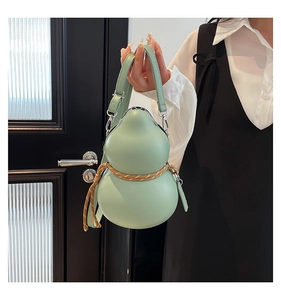 Détail du sac gourde vert menthe avec sangle tressée et garnitures en métal argenté