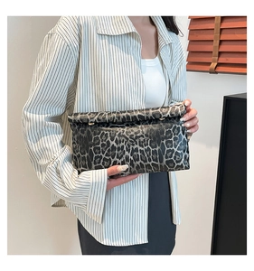 Detail of a leopard print envelope clutch bag with metal hardware and fold-over closure