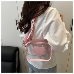 Dettaglio borsa a tracolla in PVC rosa trasparente con patch a cuore e mini portamonete