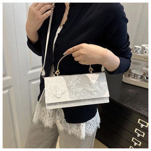 Lace crossbody bag with white butterfly appliqués shown on model for size reference
