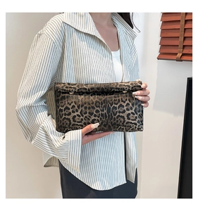 Dettaglio della pochette rettangolare leopardata con borchie metalliche tenuta da modella