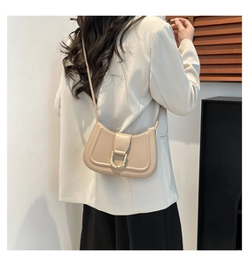 Vista dettagliata della borsa a mezzaluna beige con fibbia in metallo dorato a forma di U
