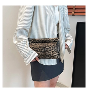 Dettaglio di una borsa a tracolla leopardata con patta indossata da una modella