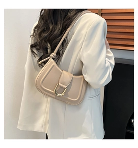 Dettaglio borsa sottobraccio beige con fibbia a U dorata e tracolla regolabile