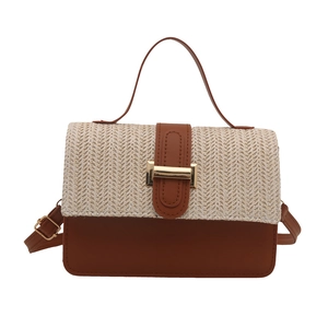 Contrast color woven straw handbag with brown leather base and adjustable shoulder strap