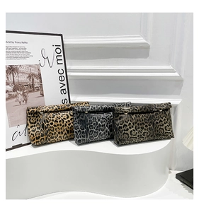 Detailed view of leopard print envelope clutches in yellow, grey, and olive with gold studs