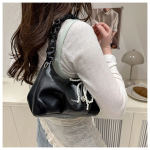 Detail of soft ruched handle and elegant pearl chain on this black shoulder cloud bag