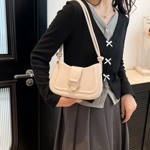 Chic beige half-moon shoulder bag with golden U-shaped buckle and knotted strap detail