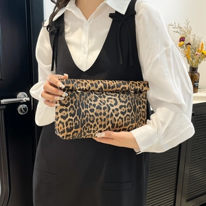 Stylish leopard print crossbody bag with chain strap shown in a modern interior setting