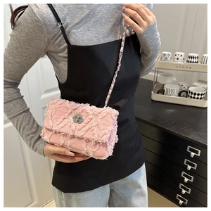Détail d'un sac bandoulière en denim rose avec bords effilochés et fermoir tournant