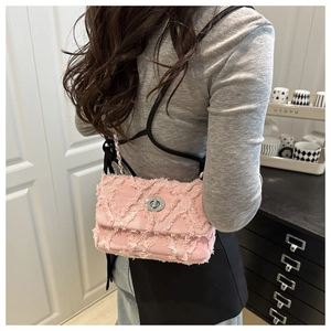 Détail du sac bandoulière en denim rose avec matelassage et bords effilochés