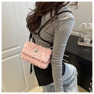 Détail du sac à bandoulière en tweed rose avec matelassage, franges et fermoir argenté