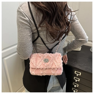 Détail du sac carré rose matelassé avec franges et bandoulière en chaîne argentée