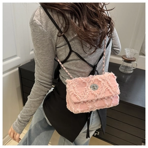 Détails du sac bandoulière en jean rose avec bords effilochés et chaîne argentée