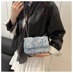 Vue détaillée du sac en denim bleu clair avec franges matelassées et fermoir argenté