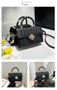Detail of black woven crossbody bag with gold floral lock and twisted handle handle detail