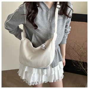 Détail du sac besace beige en velours côtelé avec un joli pendentif mouton blanc