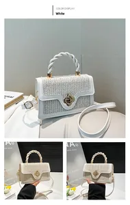 Detail of white woven handbag with golden flower lock and spiral handle close-up