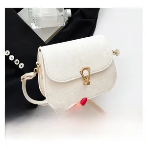 Détail du sac selle blanc en similicuir serpent avec boucle dorée et fine bandoulière