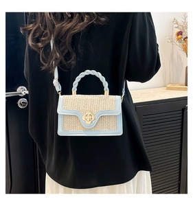 Detail of a woven color-block crossbody bag featuring a golden floral lock and twisted handle