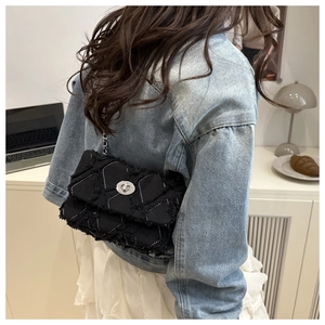 Détail du sac à chaîne matelassé noir avec franges et fermoir argenté en style de vie
