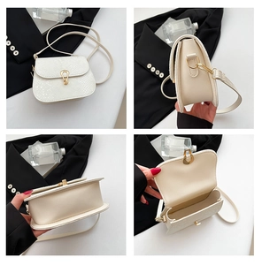 Gros plan sur le sac besace blanc crème avec motif serpent et détails en métal doré