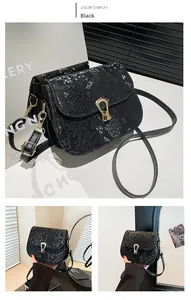 Détail du petit sac carré noir à motif serpent avec fermoir bouclier doré vintage